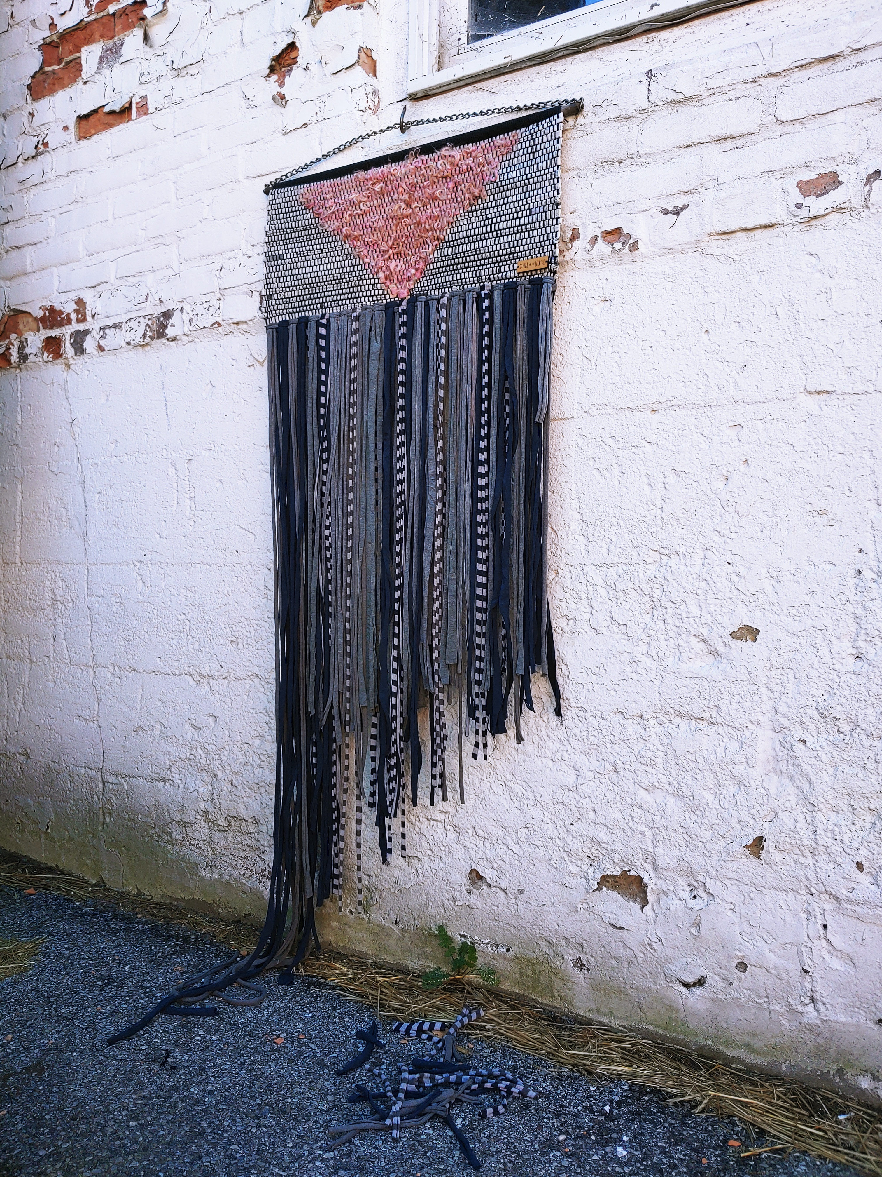 Silence=Death woven tapestry, materials: newspaper, pink fleece locks, salvaged selvedge, wood, chain